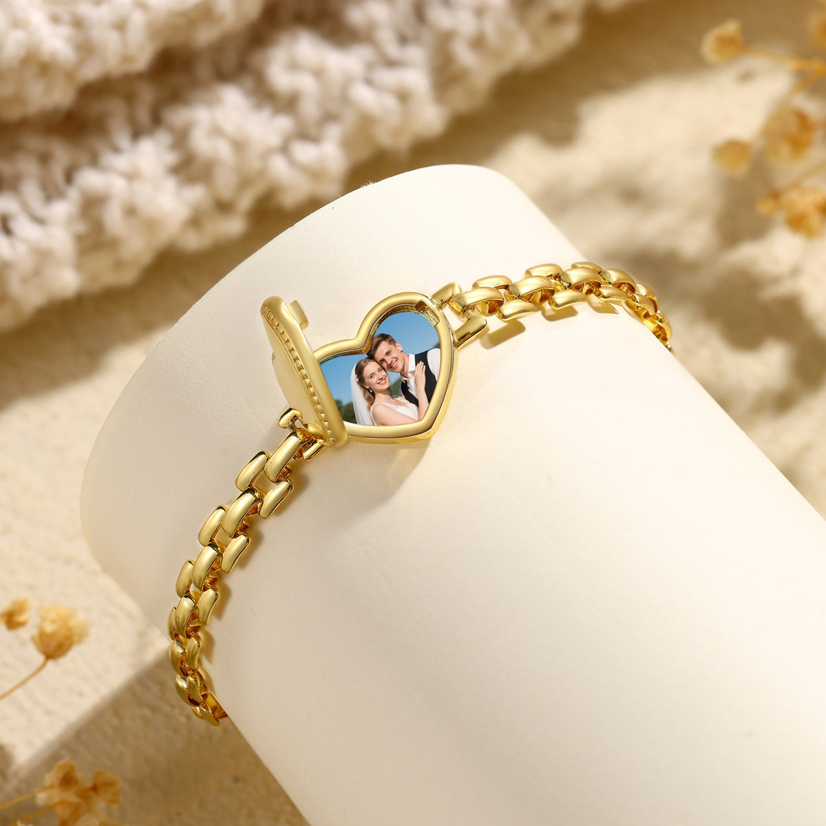 Open heart photo locket bracelet displayed on a cream jewellery stand