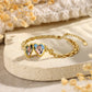 Gold-plated photo heart bracelet displayed on a stone surface with the locket open